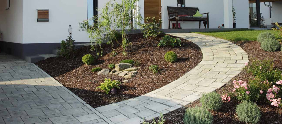 Gepflasterter Weg durch eine Gartenanlage